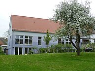 Außenansicht des Gebäudes der Rückseite mit Grünflächen.