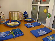 Der Schlafraum des Kindergartens. Auf dem Boden liegen Matratzen mit Kissen und Decken.