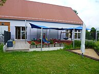 Außenansicht des Gebäudes, es ist eine Terasse zu sehen.